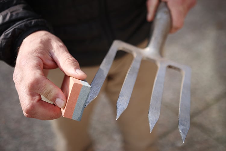 sharpening a garden fork.