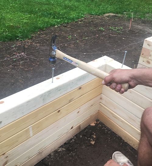 Pounding spikes in a raised bed.