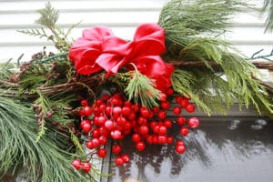 Garland decoration such as a bow and faux berries help brighten up an otherwise plain garland.