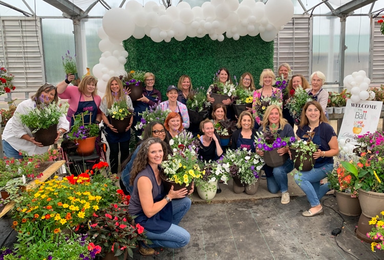 Group of gardeners holding containers they designed